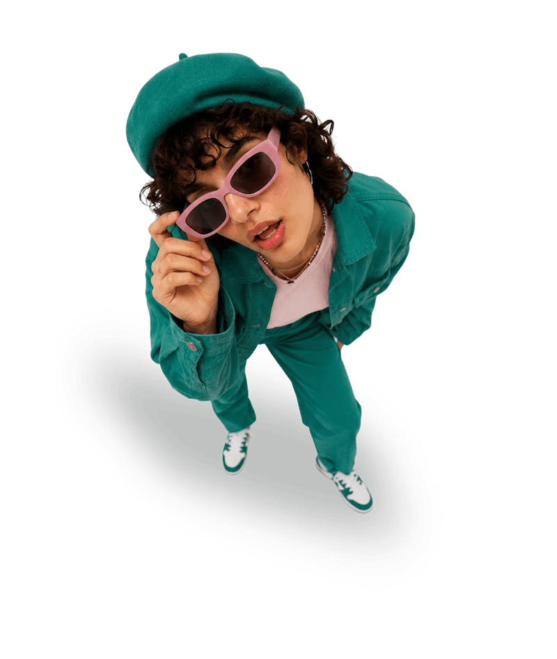 Woman in teal looking upward through pink sunglasses